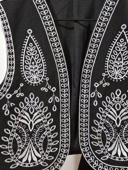 A black vest embroidered in white 