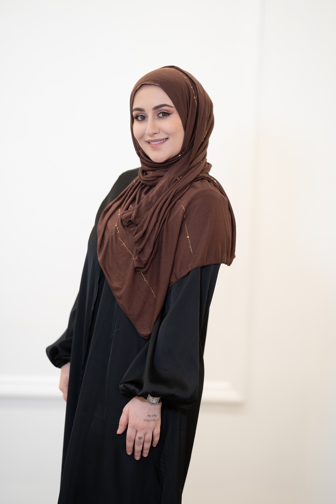 A brown cotton shawl with shiny gold beads throughout the entire shawl. 